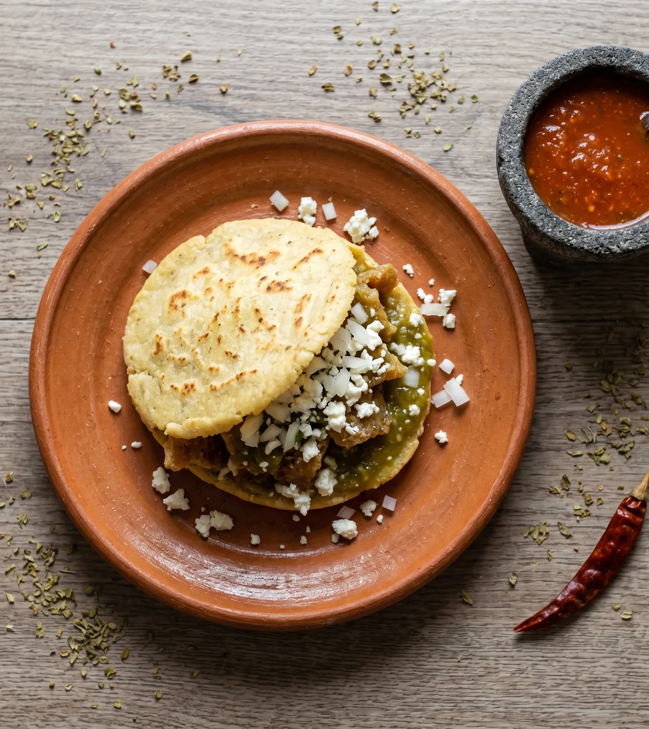 Gordita de chicharrón con salsa verde y queso
